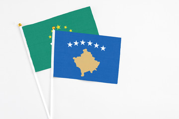 Kosovo and Macao stick flags on white background. High quality fabric, miniature national flag. Peaceful global concept.White floor for copy space.