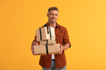 happy man holding presents isolated on orange