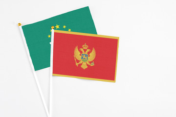 Montenegro and Macao stick flags on white background. High quality fabric, miniature national flag. Peaceful global concept.White floor for copy space.
