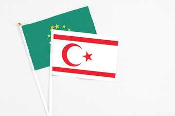 Northern Cyprus and Macao stick flags on white background. High quality fabric, miniature national flag. Peaceful global concept.White floor for copy space.