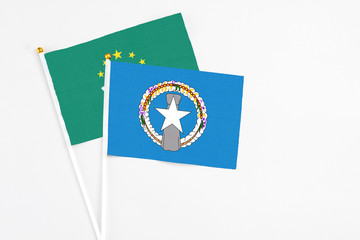 Northern Mariana Islands and Macao stick flags on white background. High quality fabric, miniature national flag. Peaceful global concept.White floor for copy space.