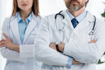 cropped view of doctors in white coats with crossed arms in hospital