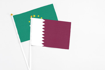 Qatar and Macao stick flags on white background. High quality fabric, miniature national flag. Peaceful global concept.White floor for copy space.