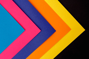 Colorful paper on black background. The view from the top. Space for text