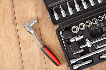 Tool set for machine repair, on wooden background. Car toolbox