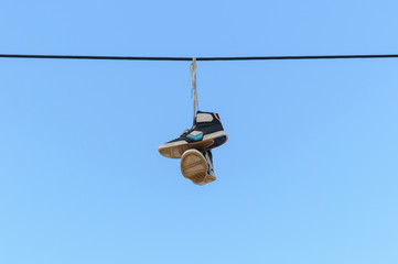 Obraz premium old sneakers hanging on a rope
