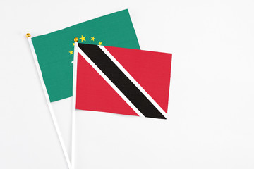 Trinidad And Tobago and Macao stick flags on white background. High quality fabric, miniature national flag. Peaceful global concept.White floor for copy space.