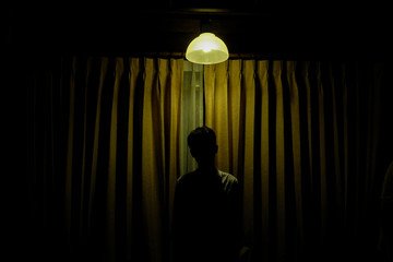 Silhouette Man under the lamp with yellow lighting