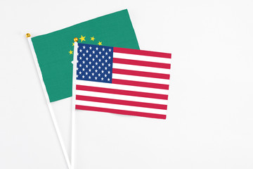 United States and Macao stick flags on white background. High quality fabric, miniature national flag. Peaceful global concept.White floor for copy space.