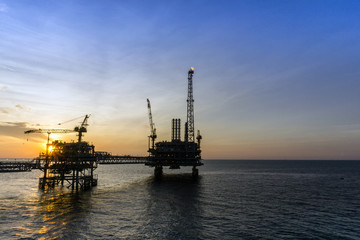 Silhouette of oil production platform at oil field