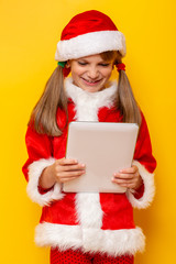 Child in Santa costume using tablet computer