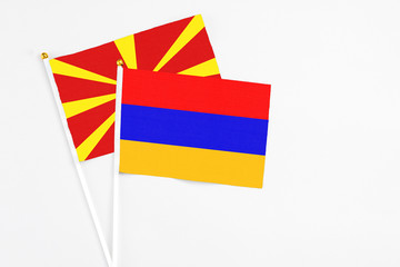 Armenia and Macedonia stick flags on white background. High quality fabric, miniature national flag. Peaceful global concept.White floor for copy space.