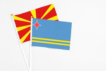 Aruba and Macedonia stick flags on white background. High quality fabric, miniature national flag. Peaceful global concept.White floor for copy space.
