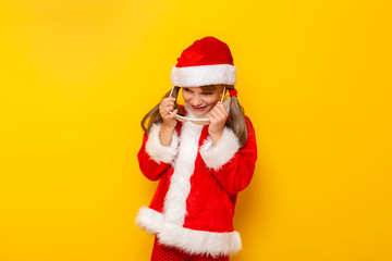 Child in Santa costume putting on party glasses