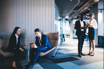 Young communicating diverse colleagues in hall