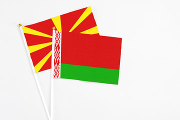 Belarus and Macedonia stick flags on white background. High quality fabric, miniature national flag. Peaceful global concept.White floor for copy space.