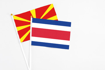 Costa Rica and Macedonia stick flags on white background. High quality fabric, miniature national flag. Peaceful global concept.White floor for copy space.