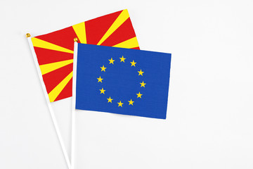 European Union and Macedonia stick flags on white background. High quality fabric, miniature national flag. Peaceful global concept.White floor for copy space.
