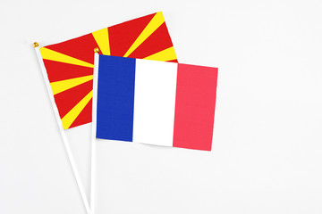 France and Macedonia stick flags on white background. High quality fabric, miniature national flag. Peaceful global concept.White floor for copy space.
