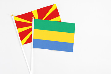 Gabon and Macedonia stick flags on white background. High quality fabric, miniature national flag....