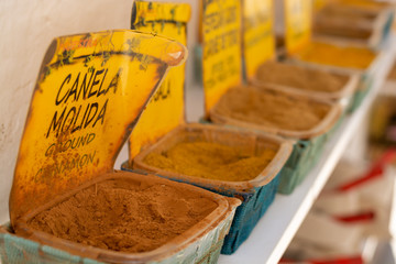 Dried kitchen herbs and different spices in boxes for sale in shop