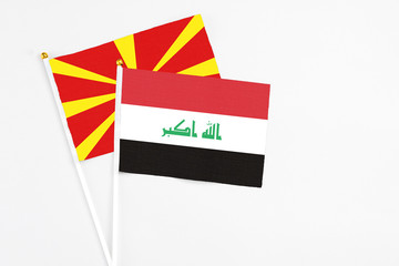 Fototapeta na wymiar Iraq and Macedonia stick flags on white background. High quality fabric, miniature national flag. Peaceful global concept.White floor for copy space.