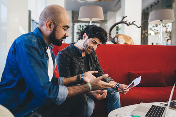 Smiling coworking men having meeting in cafe