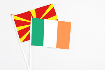 Ireland and Macedonia stick flags on white background. High quality fabric, miniature national flag. Peaceful global concept.White floor for copy space.