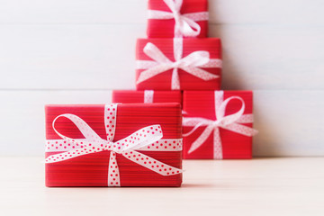 Packaged in the same style red gift boxes over white wooden background