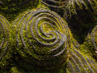Temple with statues covered with moss on the island of Bali