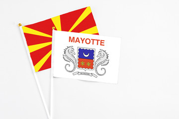 Mayotte and Macedonia stick flags on white background. High quality fabric, miniature national flag. Peaceful global concept.White floor for copy space.