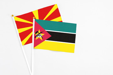 Mozambique and Macedonia stick flags on white background. High quality fabric, miniature national flag. Peaceful global concept.White floor for copy space.