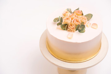 Beautiful floral cake for birthday, anniversary or weeding. White cake decorated by amazing roses on white plate