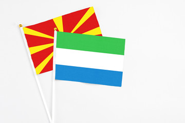 Sierra Leone and Macedonia stick flags on white background. High quality fabric, miniature national flag. Peaceful global concept.White floor for copy space.