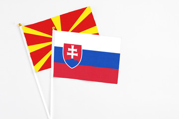 Slovakia and Macedonia stick flags on white background. High quality fabric, miniature national flag. Peaceful global concept.White floor for copy space.
