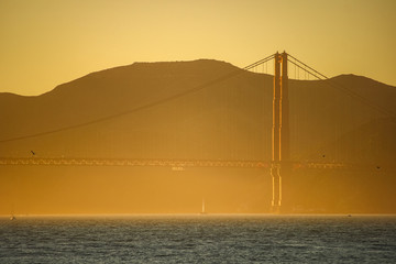 Golden Gate Bridge sunrise in the morning with beautiful yellow colored mist, San Francisco Bay