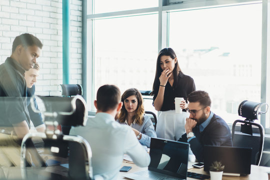 Confident Male And Female Business Owners Discussing Trade Accounting And Management Strategy For Company, Young Group Of People In Formal Wear Collaborating Together During Teamwork In Office