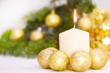 burning white candle on the background of the New Year Christmas tree, golden balls. on white background. festive mood, the sacrament of Christmas.