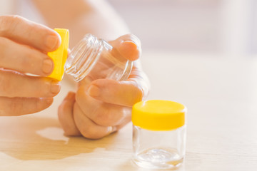 woman's old hand opening a small jar, glass pot jar  E