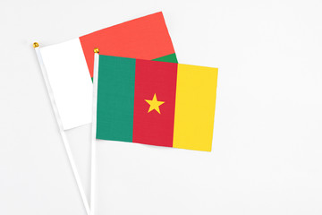 Cameroon and Madagascar stick flags on white background. High quality fabric, miniature national flag. Peaceful global concept.White floor for copy space.