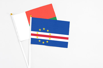 Cape Verde and Madagascar stick flags on white background. High quality fabric, miniature national flag. Peaceful global concept.White floor for copy space.