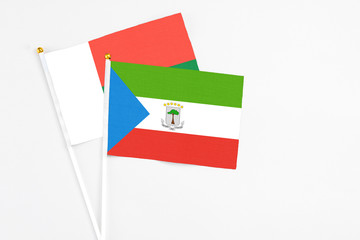 Equatorial Guinea and Madagascar stick flags on white background. High quality fabric, miniature national flag. Peaceful global concept.White floor for copy space.