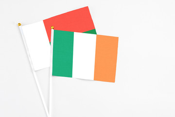 Ireland and Madagascar stick flags on white background. High quality fabric, miniature national flag. Peaceful global concept.White floor for copy space.
