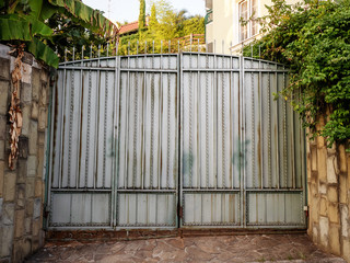 Large painted gates with wrought iron elements front view