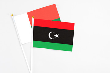 Libya and Madagascar stick flags on white background. High quality fabric, miniature national flag. Peaceful global concept.White floor for copy space.