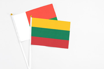 Lithuania and Madagascar stick flags on white background. High quality fabric, miniature national flag. Peaceful global concept.White floor for copy space.
