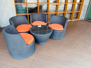 A Wicker chairs with soft pillows and table on the outdoor terrace.