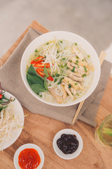 Traditional vietnamese noodle soups pho in bowls, concrete background. Vietnamese beef soup pho bo,...
