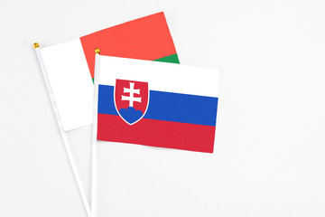 Slovakia and Madagascar stick flags on white background. High quality fabric, miniature national flag. Peaceful global concept.White floor for copy space.