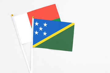 Solomon Islands and Madagascar stick flags on white background. High quality fabric, miniature...